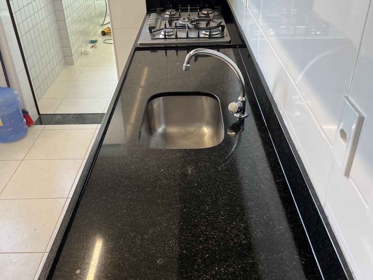 Bancada de granito preto limpa após o serviço de pós-obra da RPR